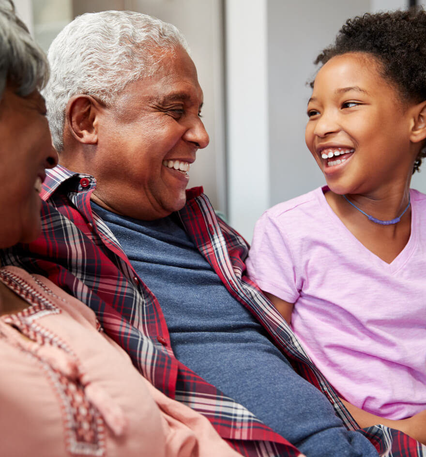 Grandparents laugh with granddaughter