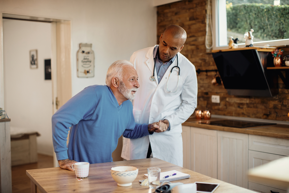 doctor helping man get up