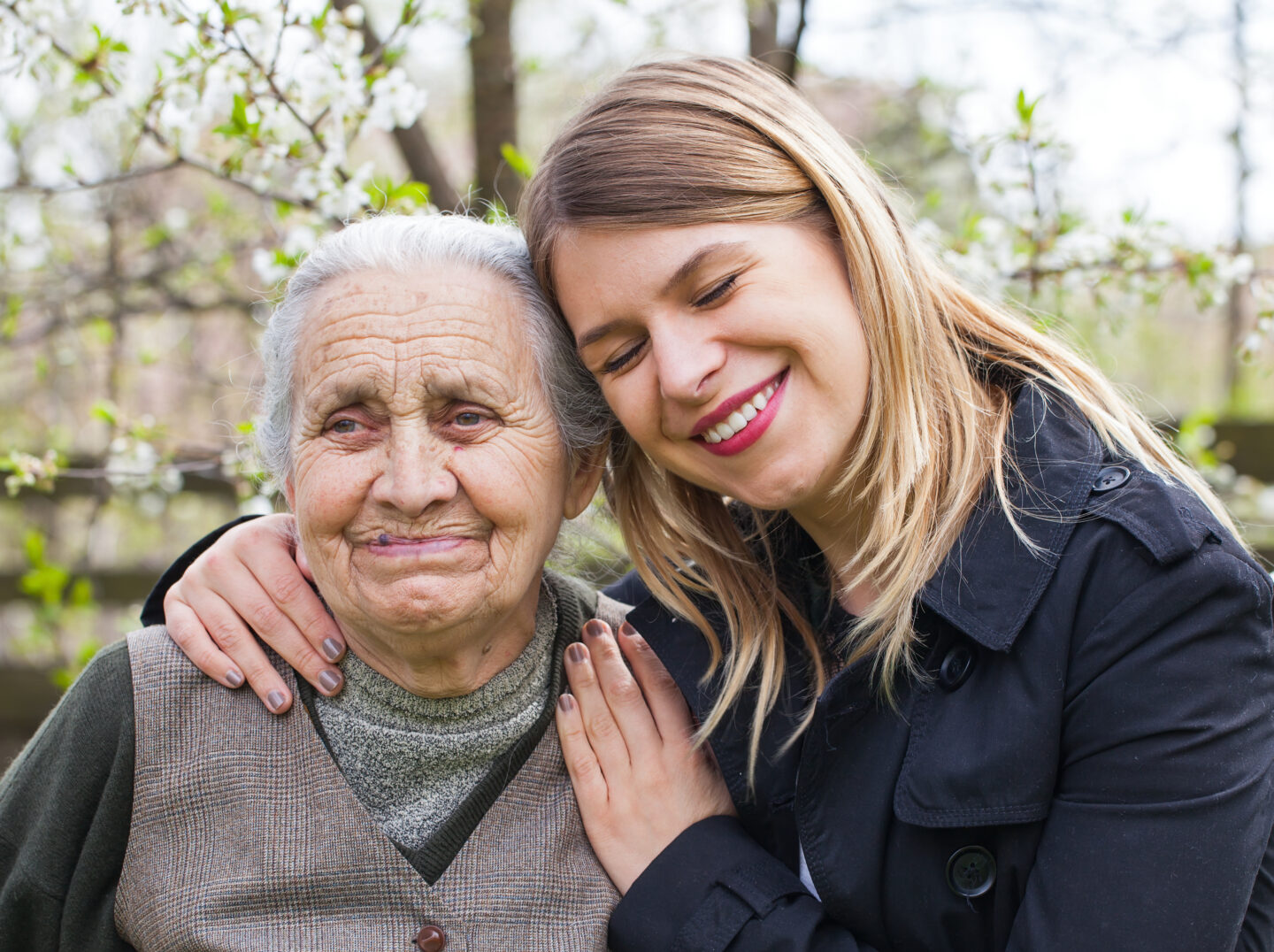 Woman hugging elderly woman suffering from dementia