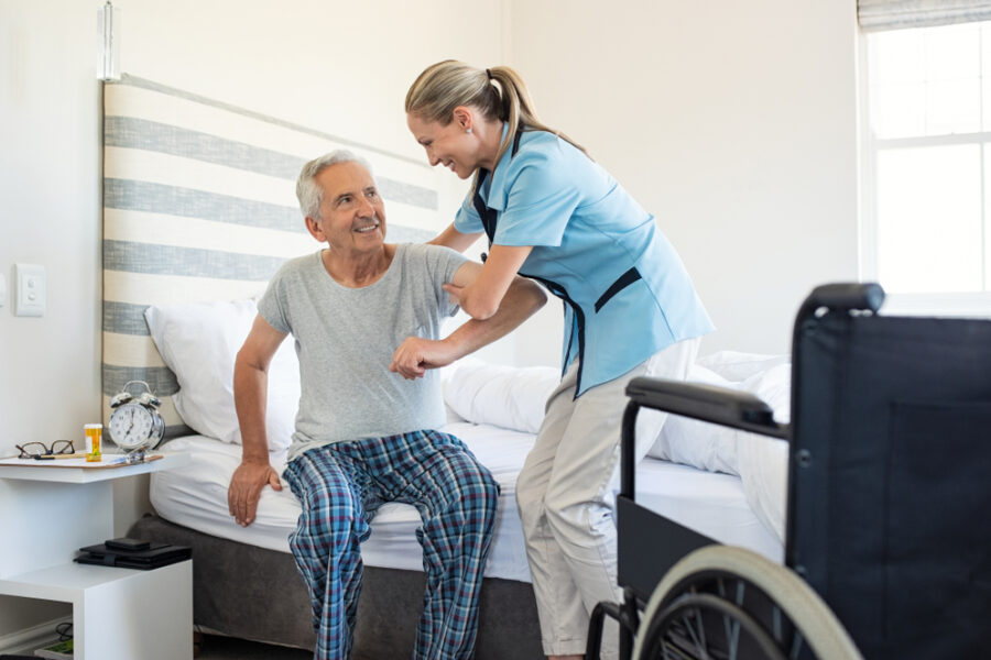 Home health care worker helps patient get out of bed and start the day with their routine