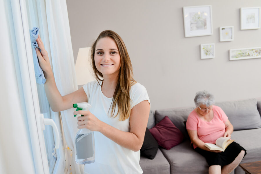 Woman cleans house for senior woman providing personal home care.